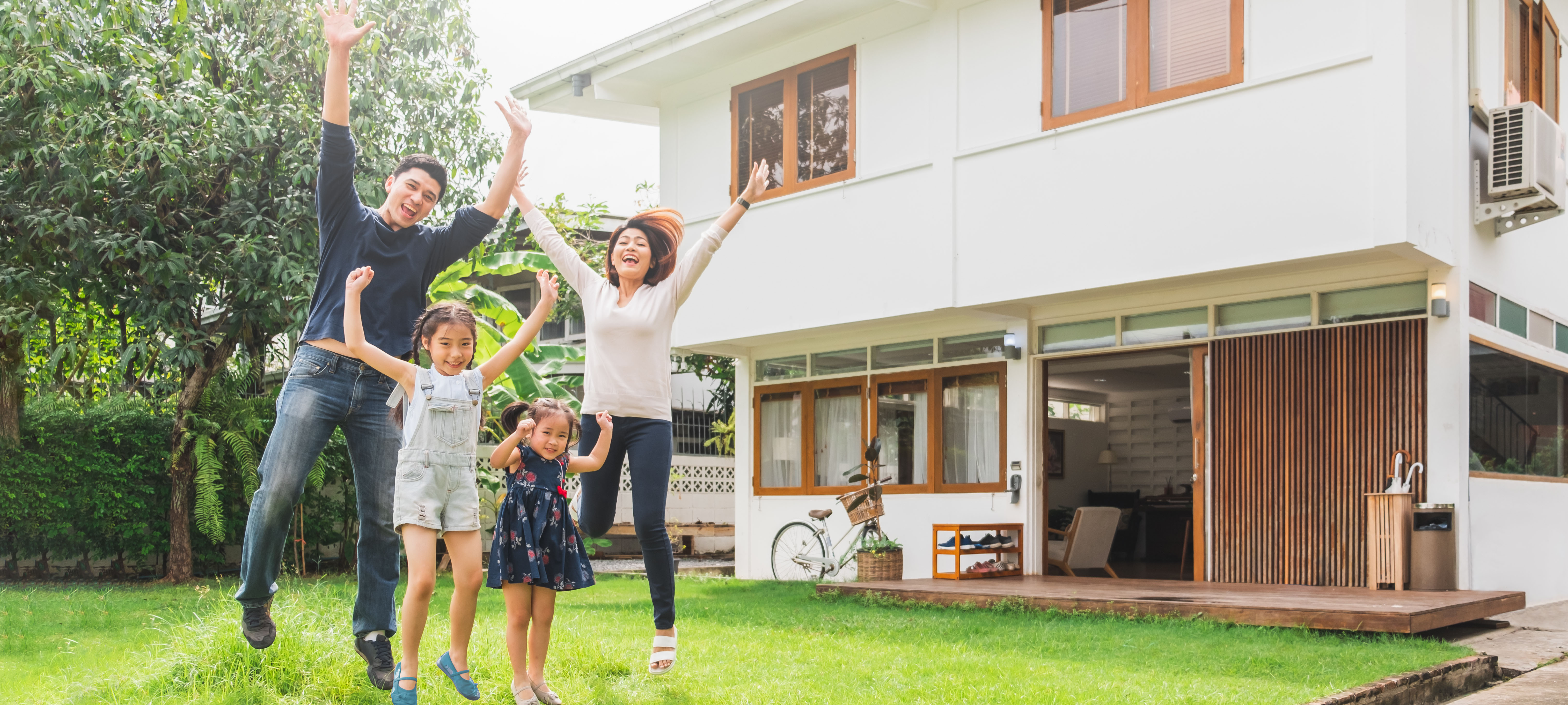 Ein Familie springt in die Luft vor ihrem Haus Ein Familie springt in die Luft vor ihrem Haus